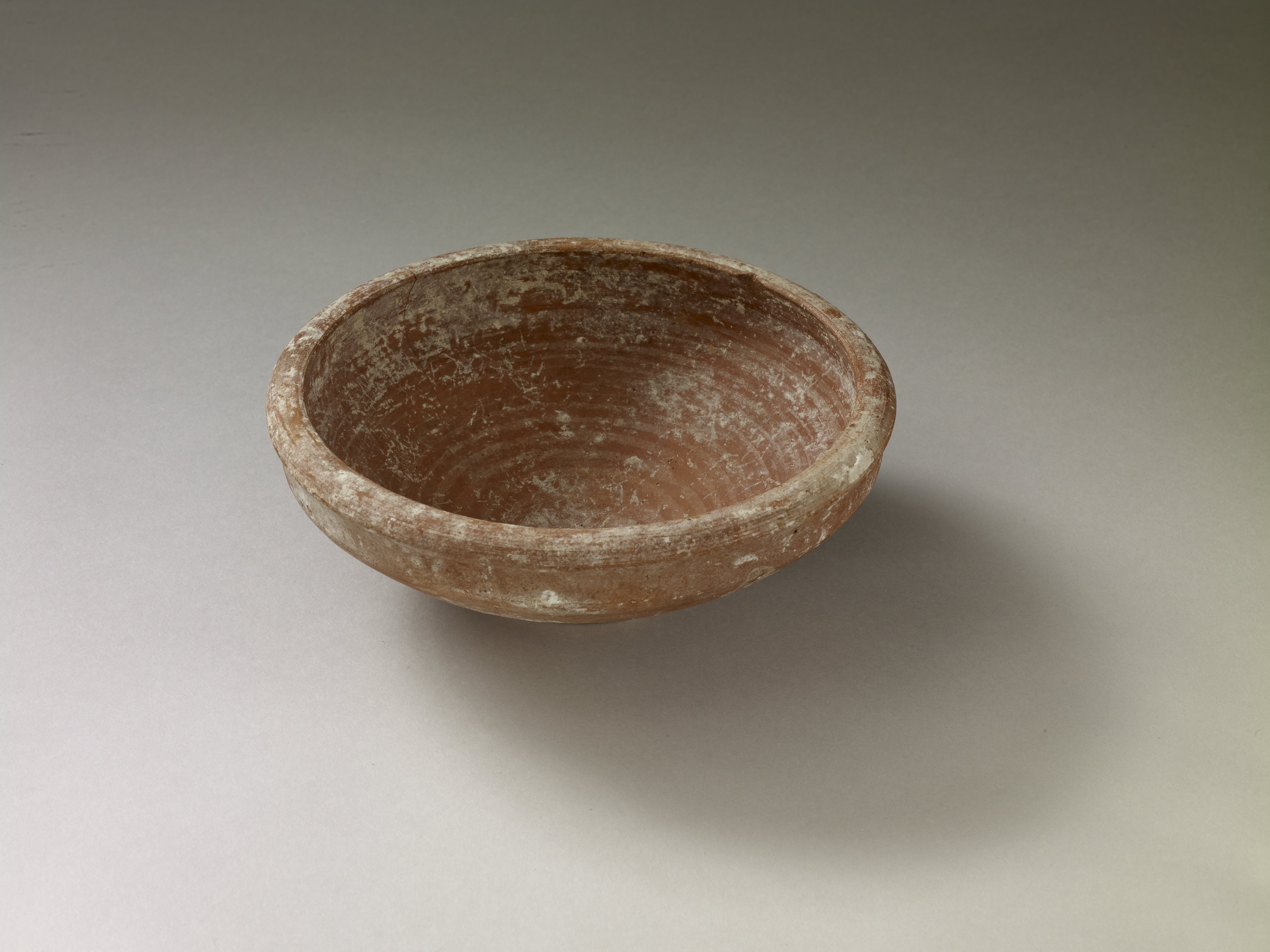 A red-slipped ceramic bowl.