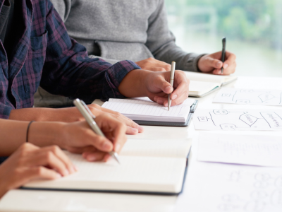 people sitting at table with notebooks