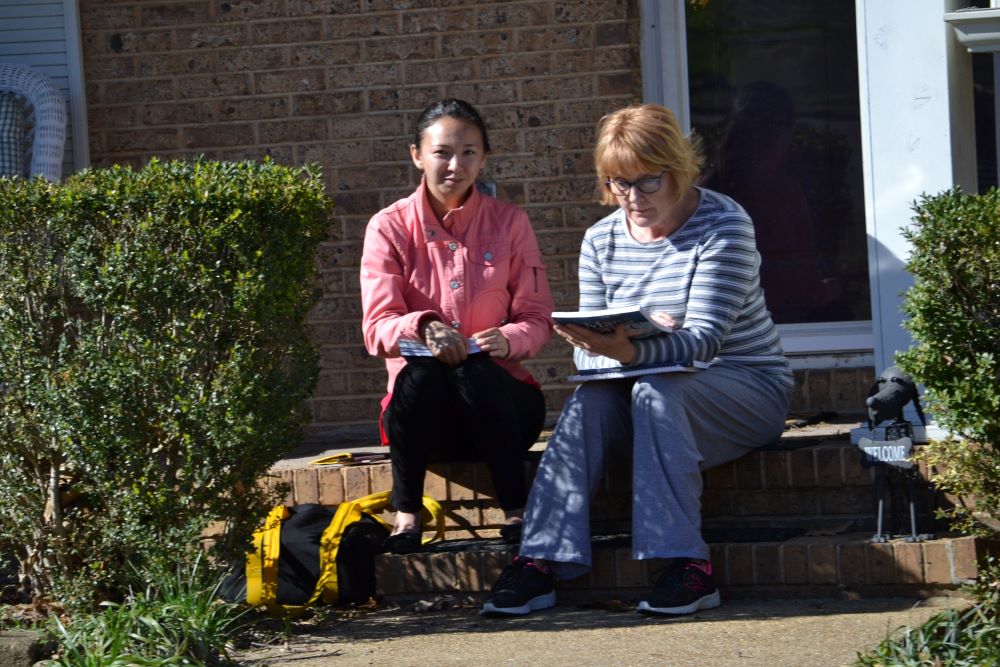 Two people sitting outside talking