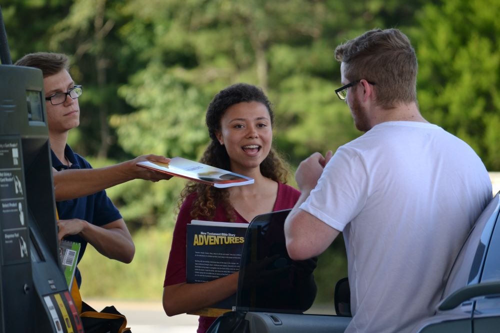 Someone handing a person a book