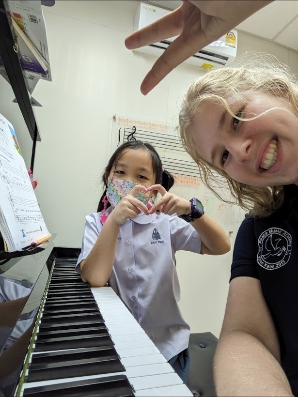 two people smiling by a piano