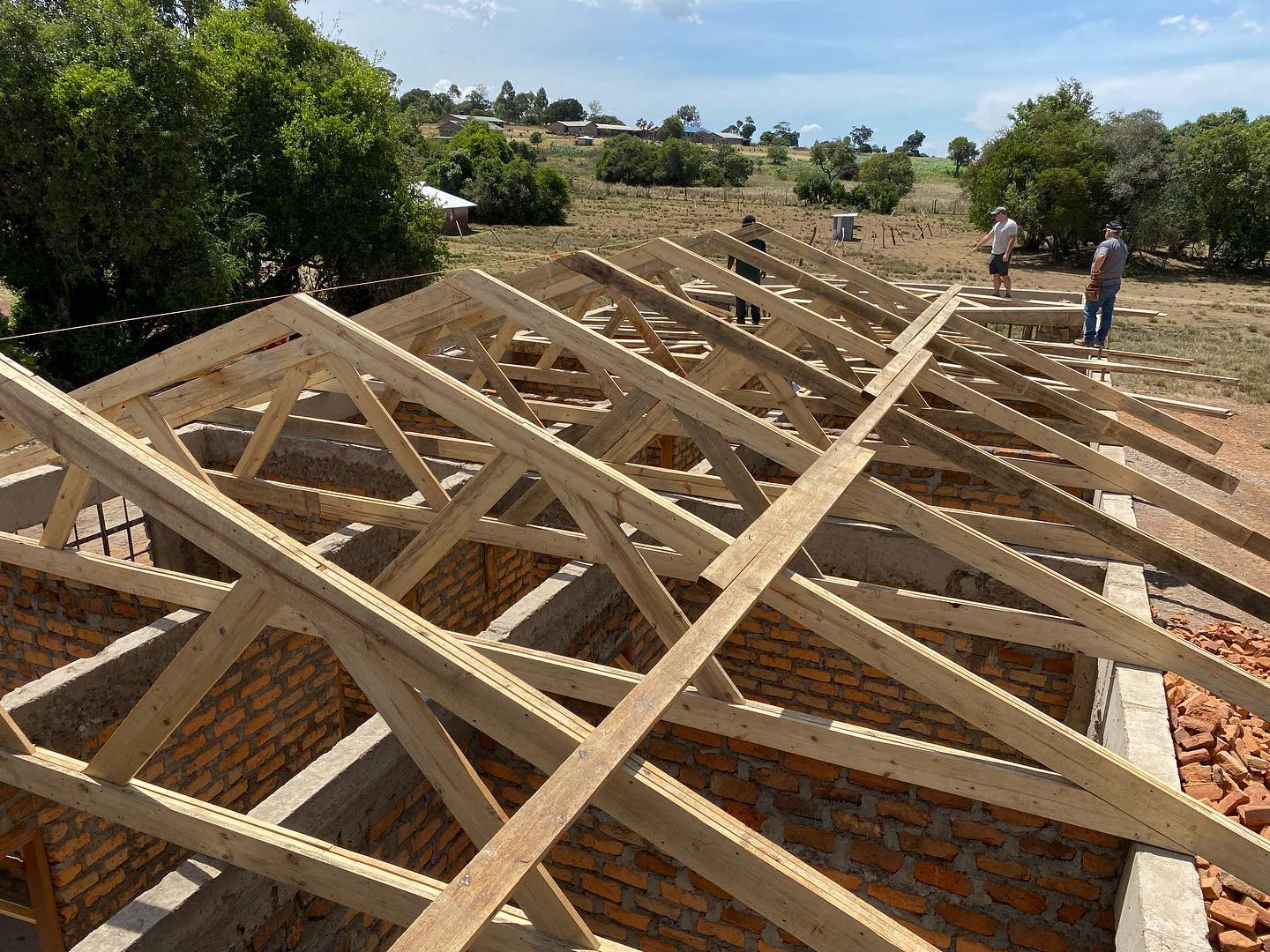 A brick building with rafters being put on