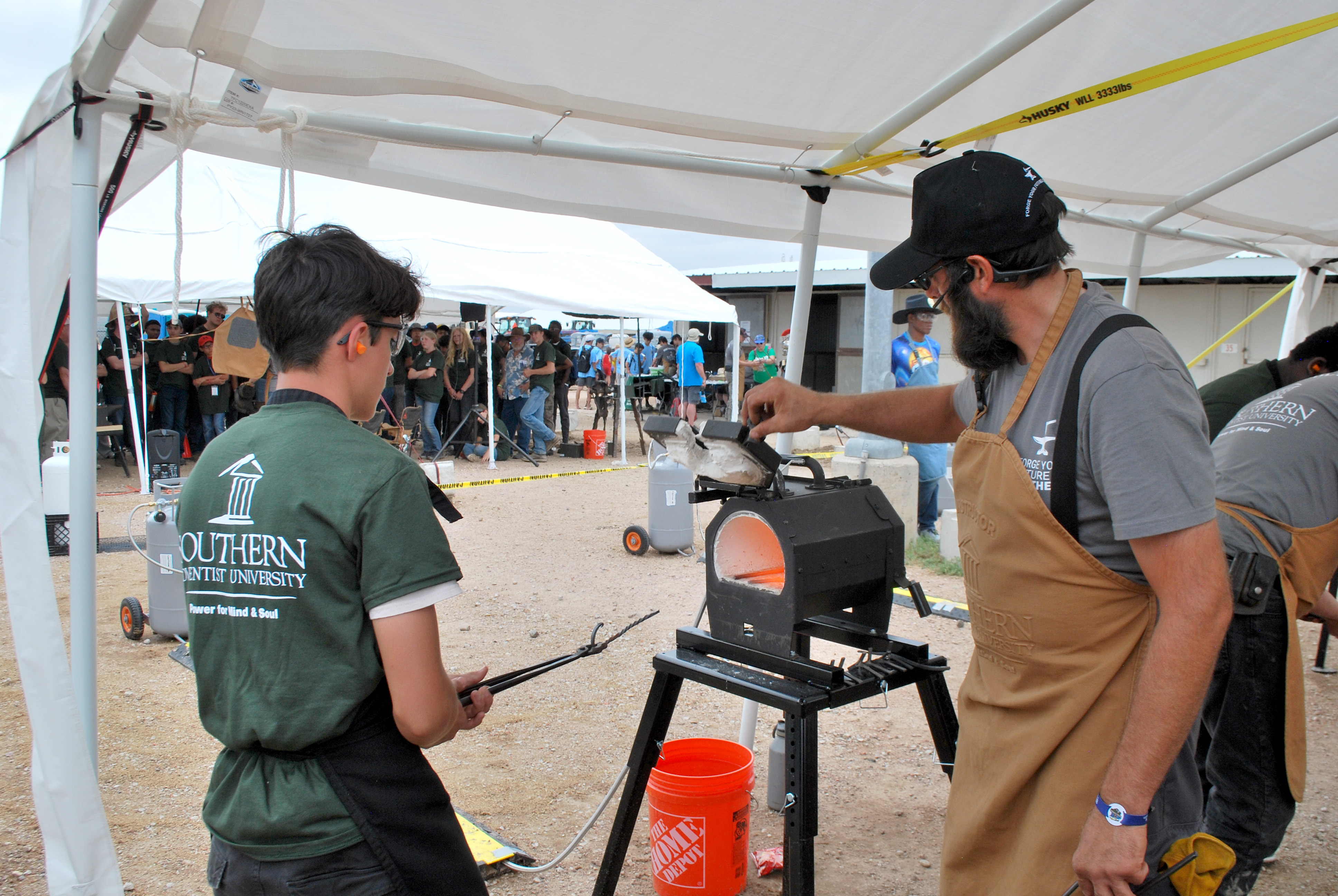 A Pathfinder uses one of the forges at Southern's blacksmithing booth.