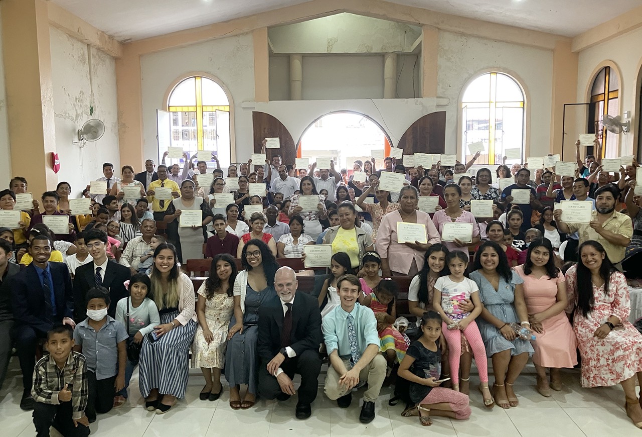 Dawson Stephens (center, in blue) meets church members in Ecuador.