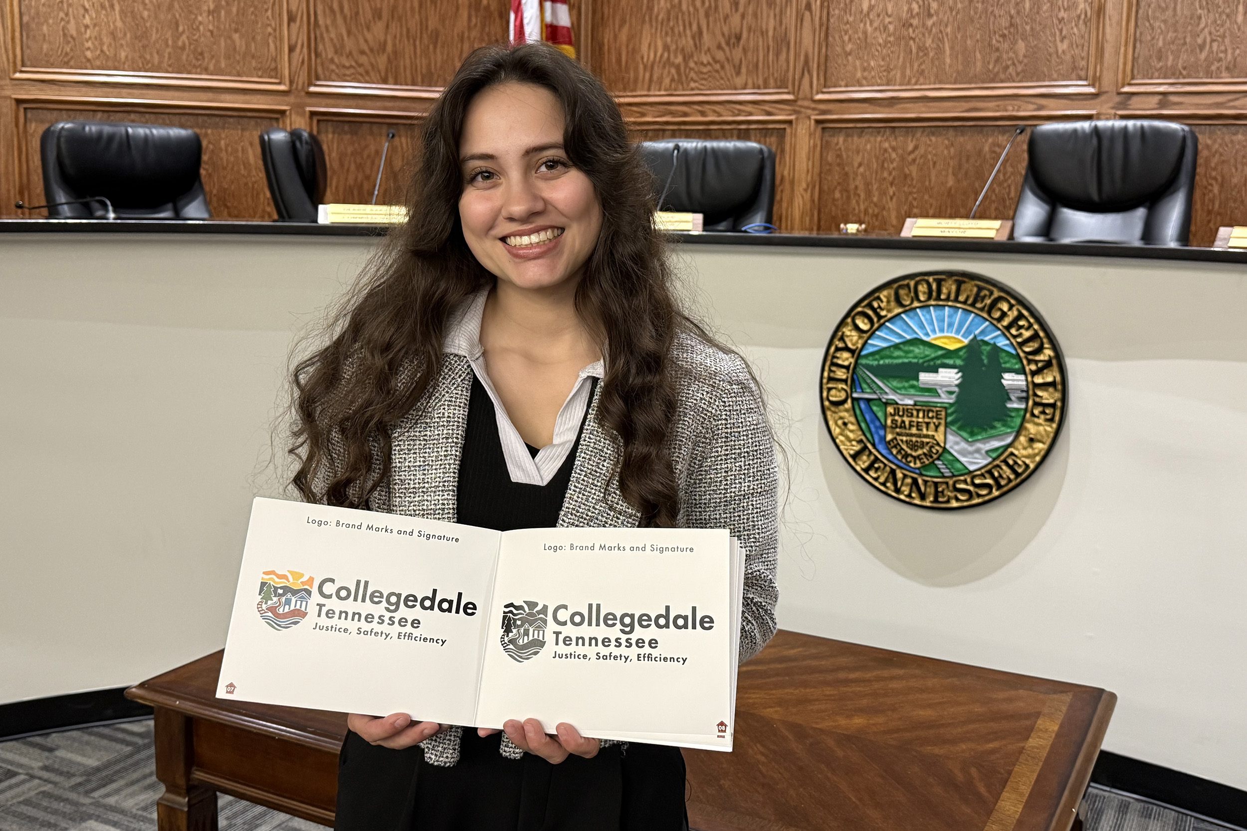 Laurissa Mancía holds her brand book featuring the new logo for Collegedale. 